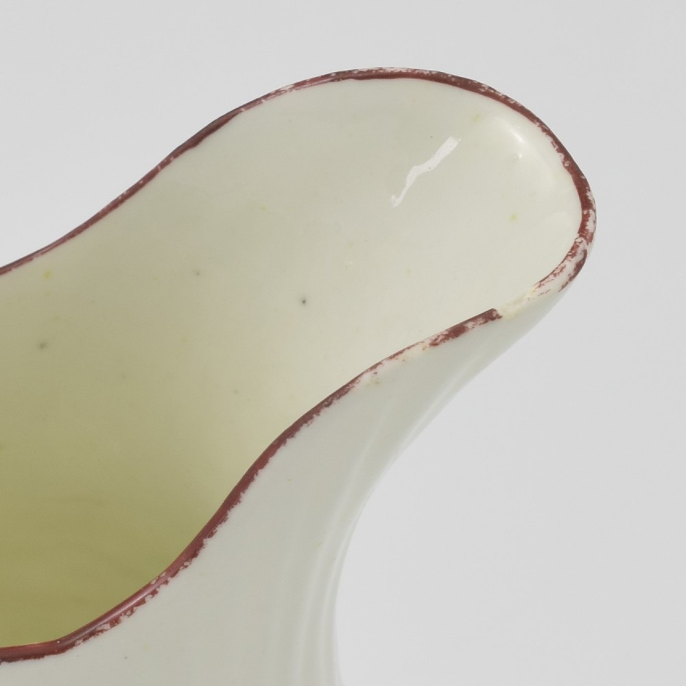 An eighteenth-century English soft-paste porcelain cream jug with vertical fluting, hand-painted floral motifs, and a looped handle. View XIII