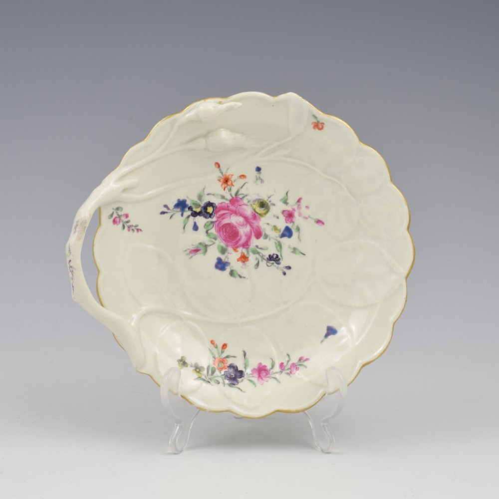 An 18th-century Worcester soft-paste porcelain sweetmeat dish featuring relief-moulded rose leaves, a branch handle, multi-coloured hand-painted floral sprays, and a gilded rim. View II