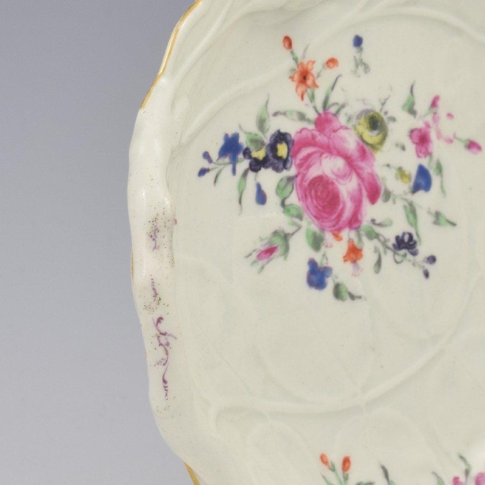 An 18th-century Worcester soft-paste porcelain sweetmeat dish featuring relief-moulded rose leaves, a branch handle, multi-coloured hand-painted floral sprays, and a gilded rim. View VI