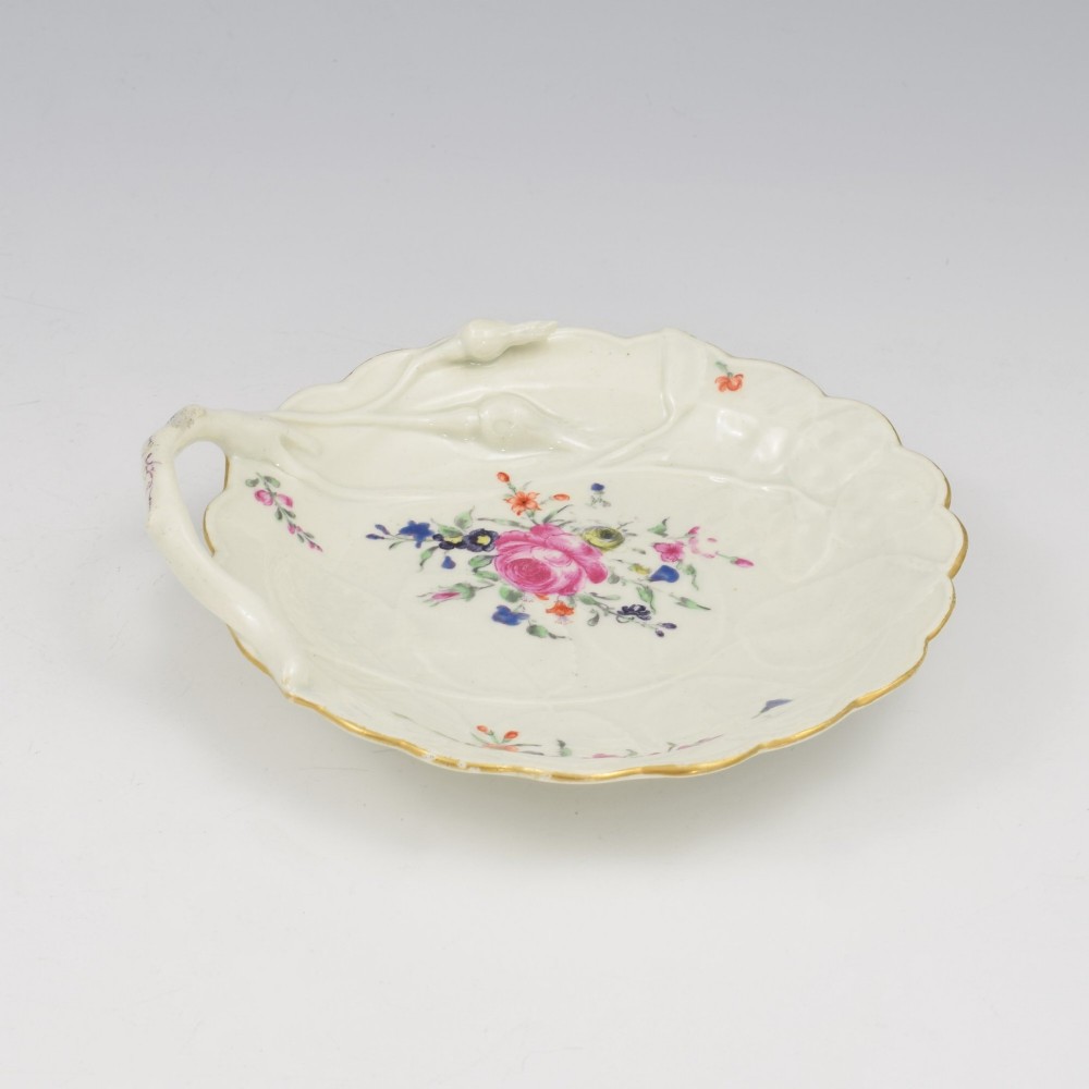 An 18th-century Worcester soft-paste porcelain sweetmeat dish featuring relief-moulded rose leaves, a branch handle, multi-coloured hand-painted floral sprays, and a gilded rim. View VIII