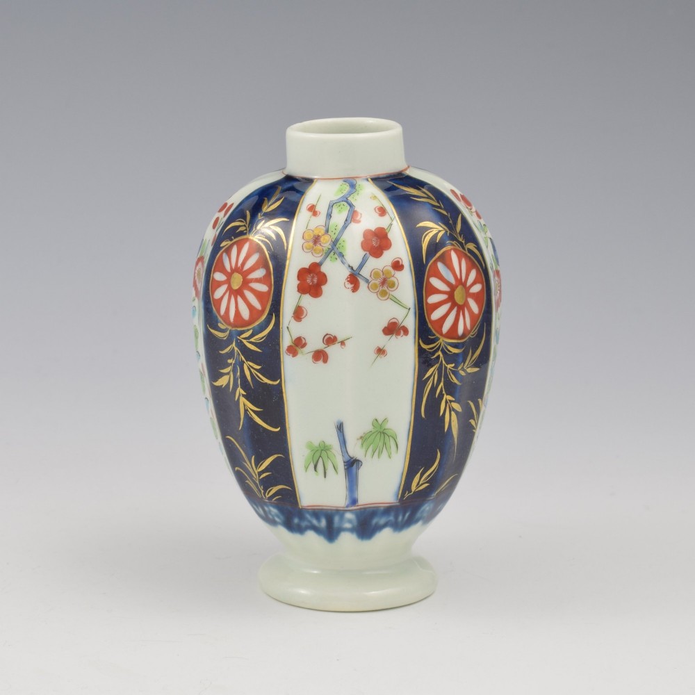 A First Period Worcester soft-paste porcelain tea canister decorated with cobalt blue panels, gilt scrolls, and polychrome floral reserves. View V