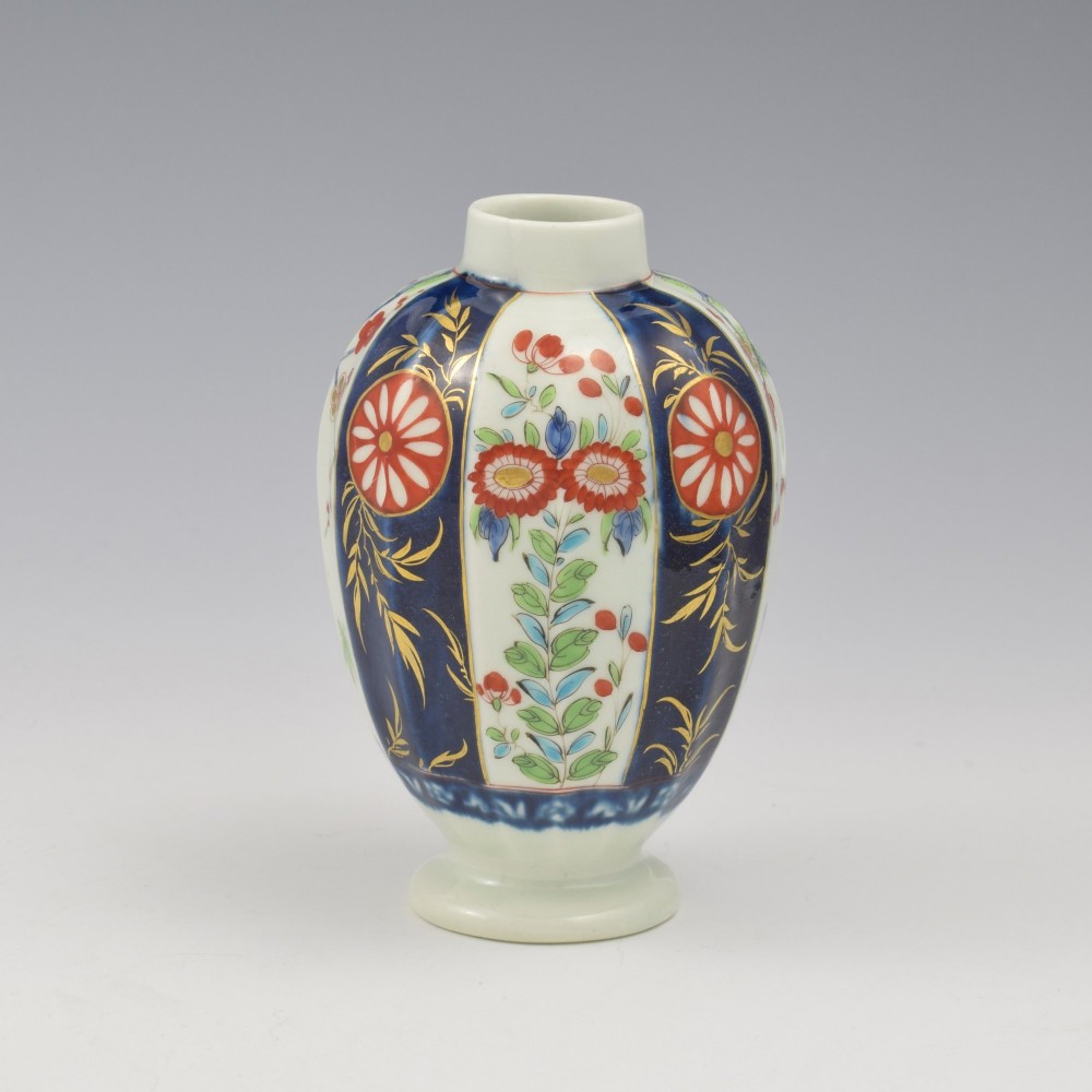 A First Period Worcester soft-paste porcelain tea canister decorated with cobalt blue panels, gilt scrolls, and polychrome floral reserves. View VI