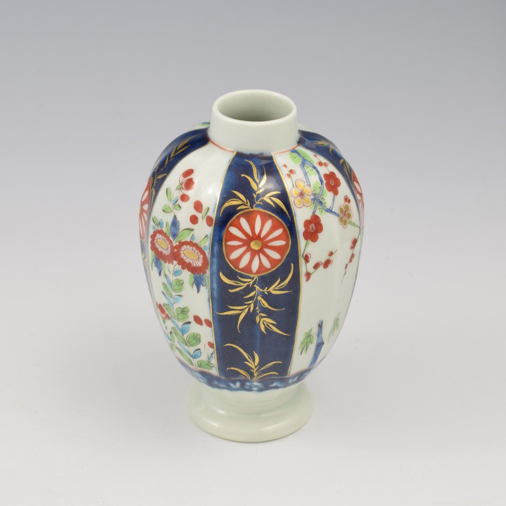 A First Period Worcester soft-paste porcelain tea canister decorated with cobalt blue panels, gilt scrolls, and polychrome floral reserves. View VIII
