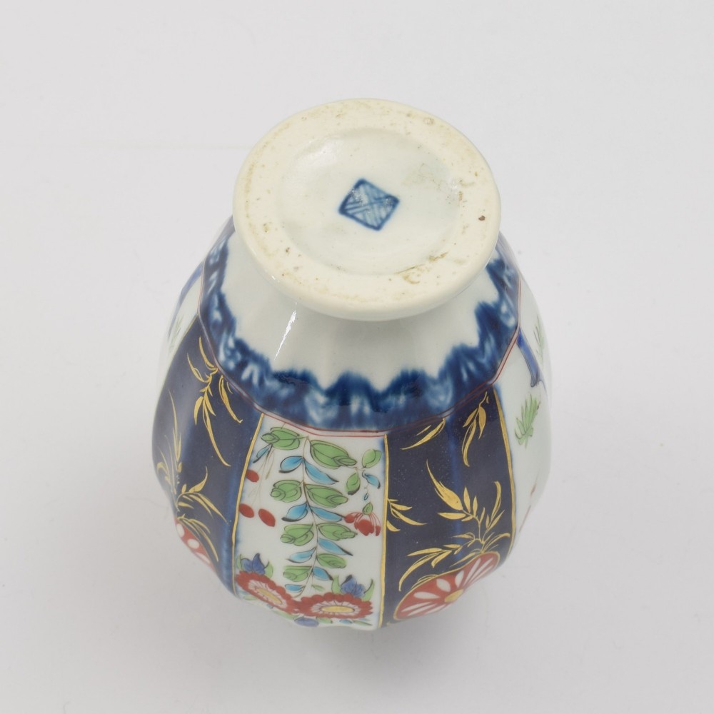 A First Period Worcester soft-paste porcelain tea canister decorated with cobalt blue panels, gilt scrolls, and polychrome floral reserves. View X
