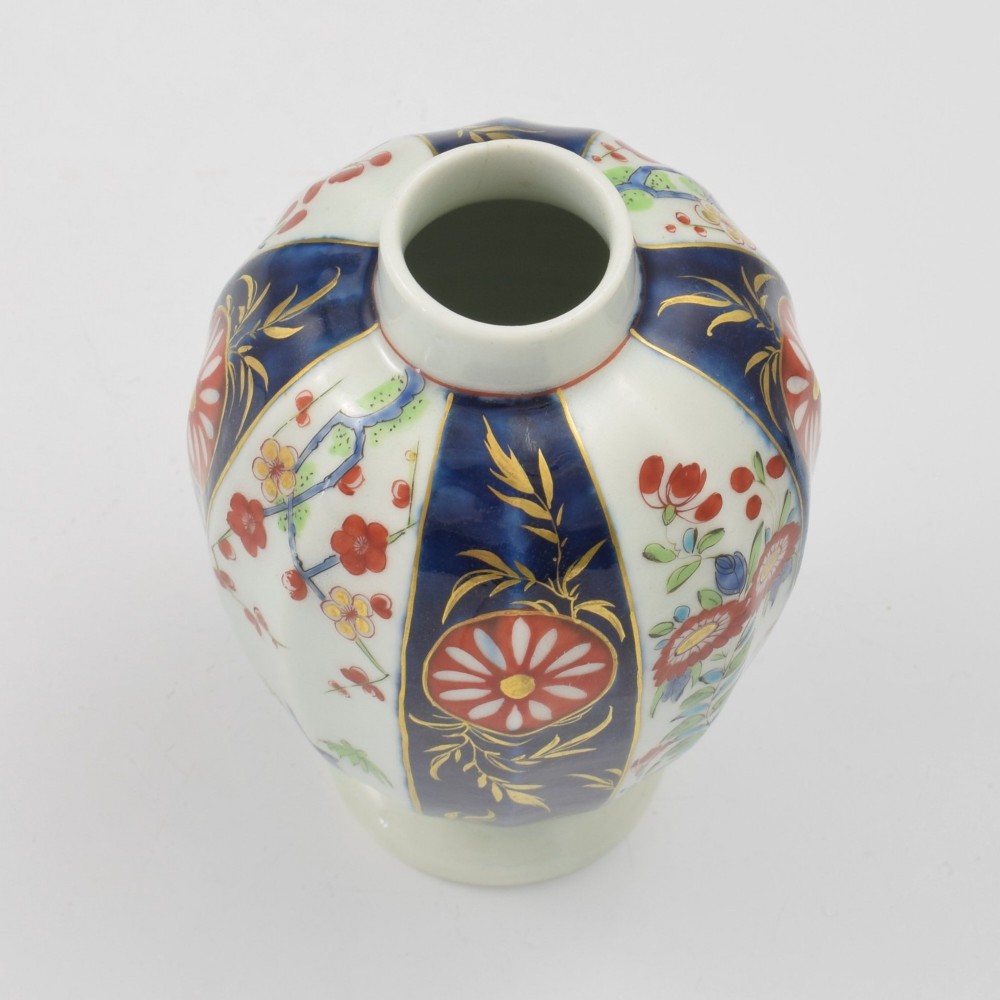 A First Period Worcester soft-paste porcelain tea canister decorated with cobalt blue panels, gilt scrolls, and polychrome floral reserves. View XI