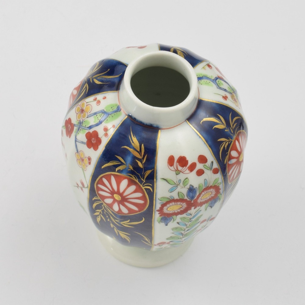 A First Period Worcester soft-paste porcelain tea canister decorated with cobalt blue panels, gilt scrolls, and polychrome floral reserves. View XII