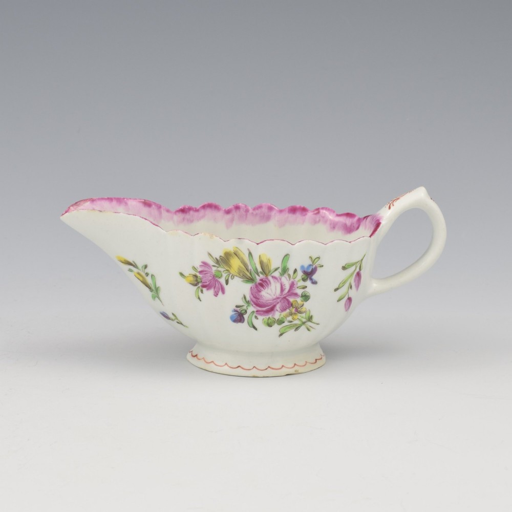 An eighteenth-century Bow soft-paste porcelain fluted sauce boat with hand-painted floral sprigs and a magenta feathered rim. View II