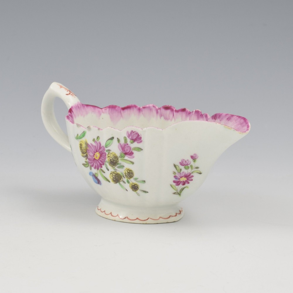 An eighteenth-century Bow soft-paste porcelain fluted sauce boat with hand-painted floral sprigs and a magenta feathered rim. View V