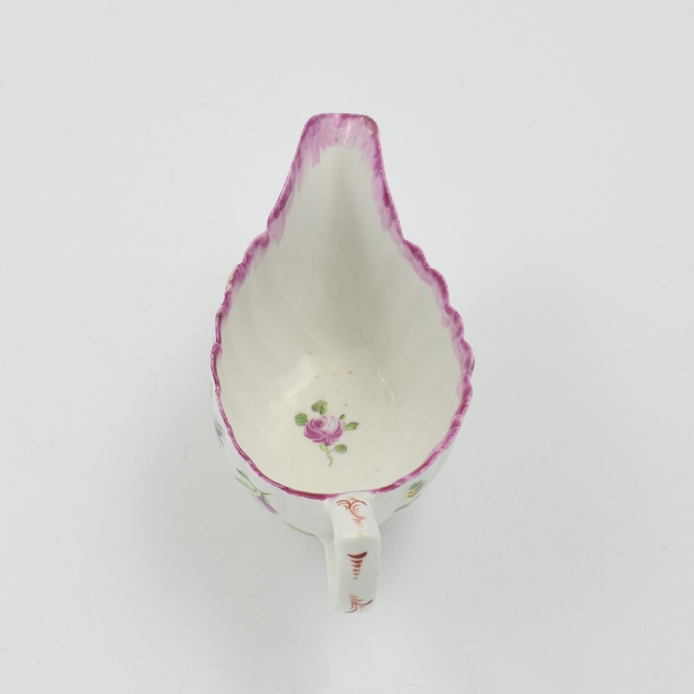 An eighteenth-century Bow soft-paste porcelain fluted sauce boat with hand-painted floral sprigs and a magenta feathered rim. View XII
