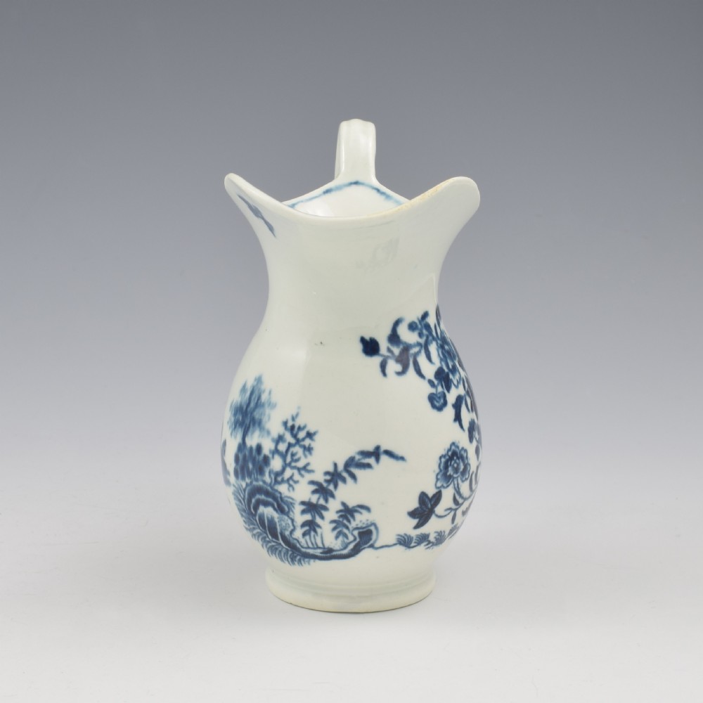 An 18th-century blue and white Worcester porcelain milk ewer featuring a flared spout, loop handle, and hand-painted floral motifs. View IV