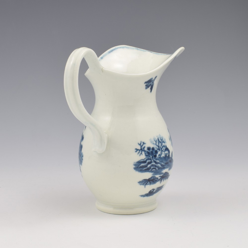 An 18th-century blue and white Worcester porcelain milk ewer featuring a flared spout, loop handle, and hand-painted floral motifs. View VIII