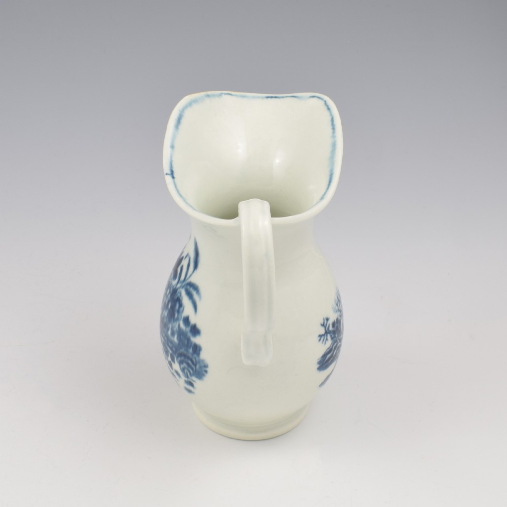 An 18th-century blue and white Worcester porcelain milk ewer featuring a flared spout, loop handle, and hand-painted floral motifs. View IX
