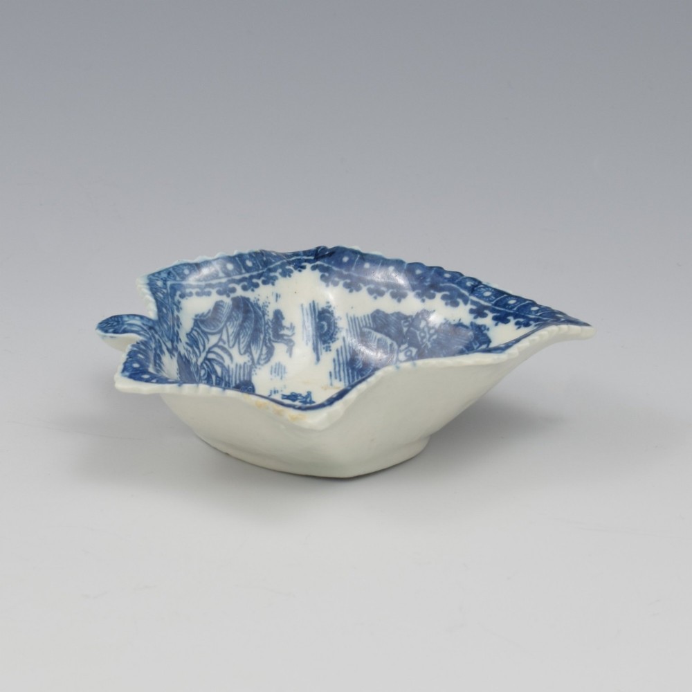 An 18th-century blue and white Caughley soft-paste porcelain pickle dish shaped like a leaf with a serrated rim and printed with a Oriental landscape pattern. View II