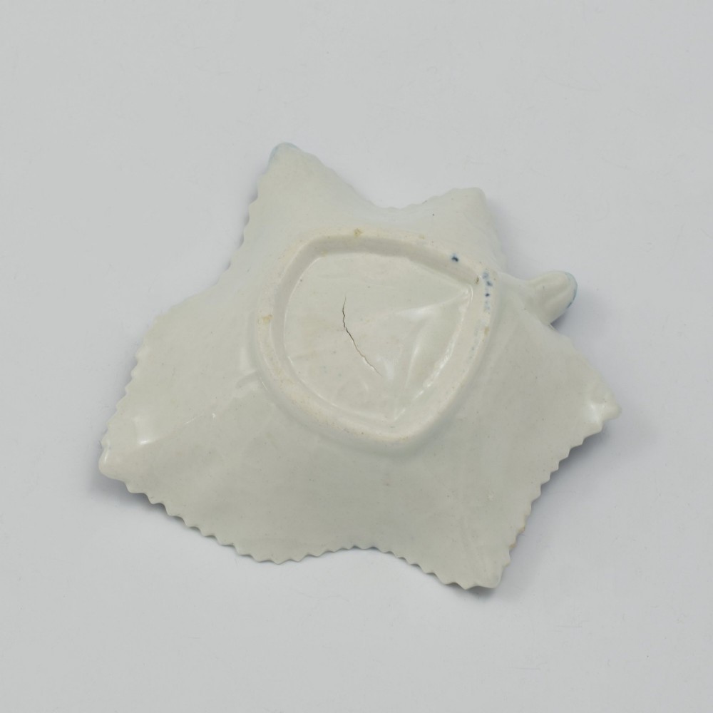 An 18th-century blue and white Caughley soft-paste porcelain pickle dish shaped like a leaf with a serrated rim and printed with a Oriental landscape pattern. View V