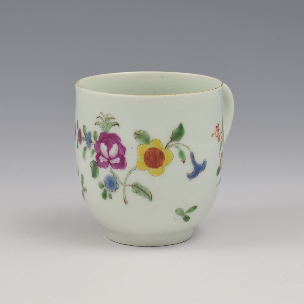 An 18th-century white porcelain coffee cup painted with polychrome floral sprays and featuring a single loop handle. View II