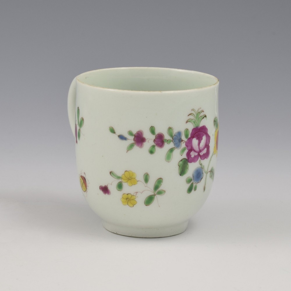 An 18th-century white porcelain coffee cup painted with polychrome floral sprays and featuring a single loop handle. View IV