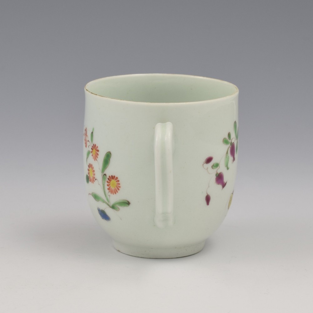 An 18th-century white porcelain coffee cup painted with polychrome floral sprays and featuring a single loop handle. View VII