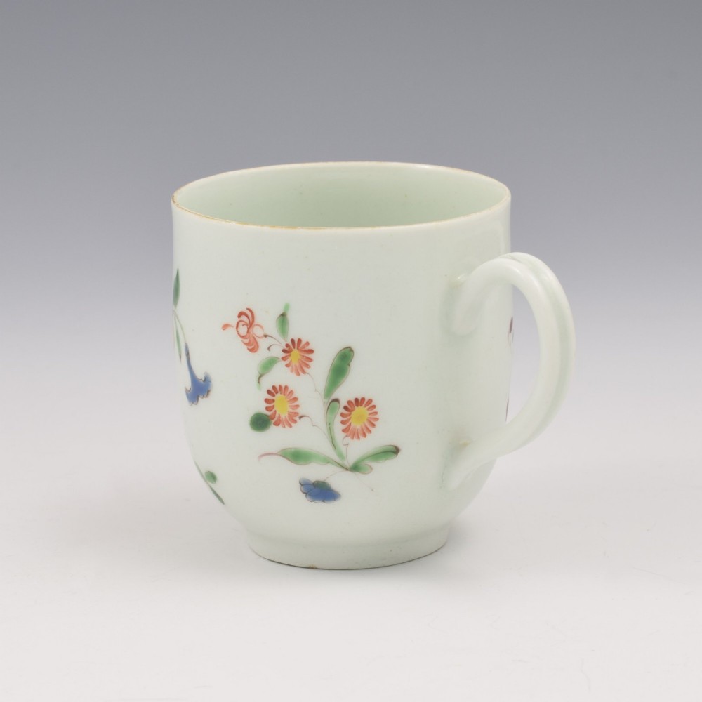 An 18th-century white porcelain coffee cup painted with polychrome floral sprays and featuring a single loop handle. View VIII