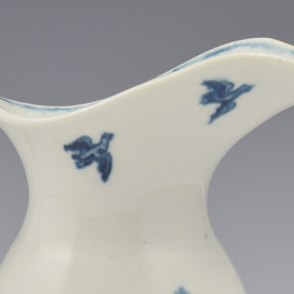 An 18th-century blue and white Worcester porcelain milk ewer featuring a flared spout, loop handle, and hand-painted floral motifs. View XIV