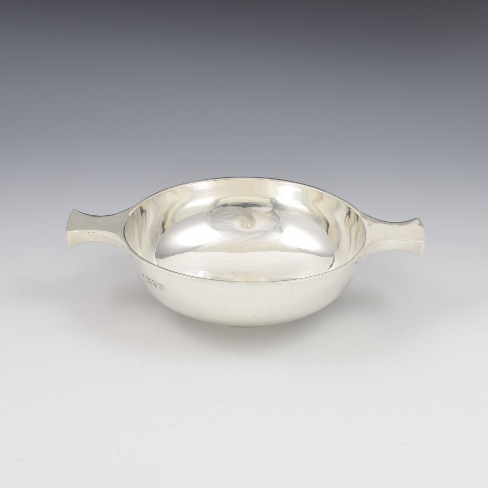 A circular Edwardian sterling silver quaich with a plain polished interior and two flat side handles. View II