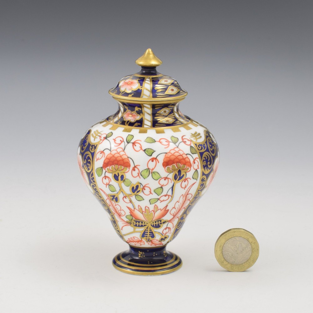 A baluster-shaped porcelain miniature vase and matching domed lid decorated with a cobalt blue, iron red, and gilt Imari pattern. View III