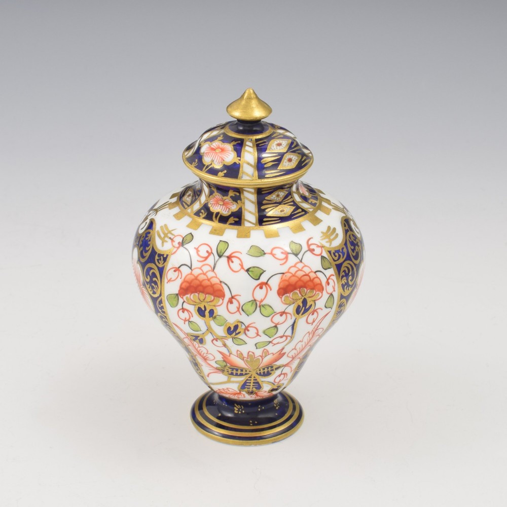 A baluster-shaped porcelain miniature vase and matching domed lid decorated with a cobalt blue, iron red, and gilt Imari pattern. View IV