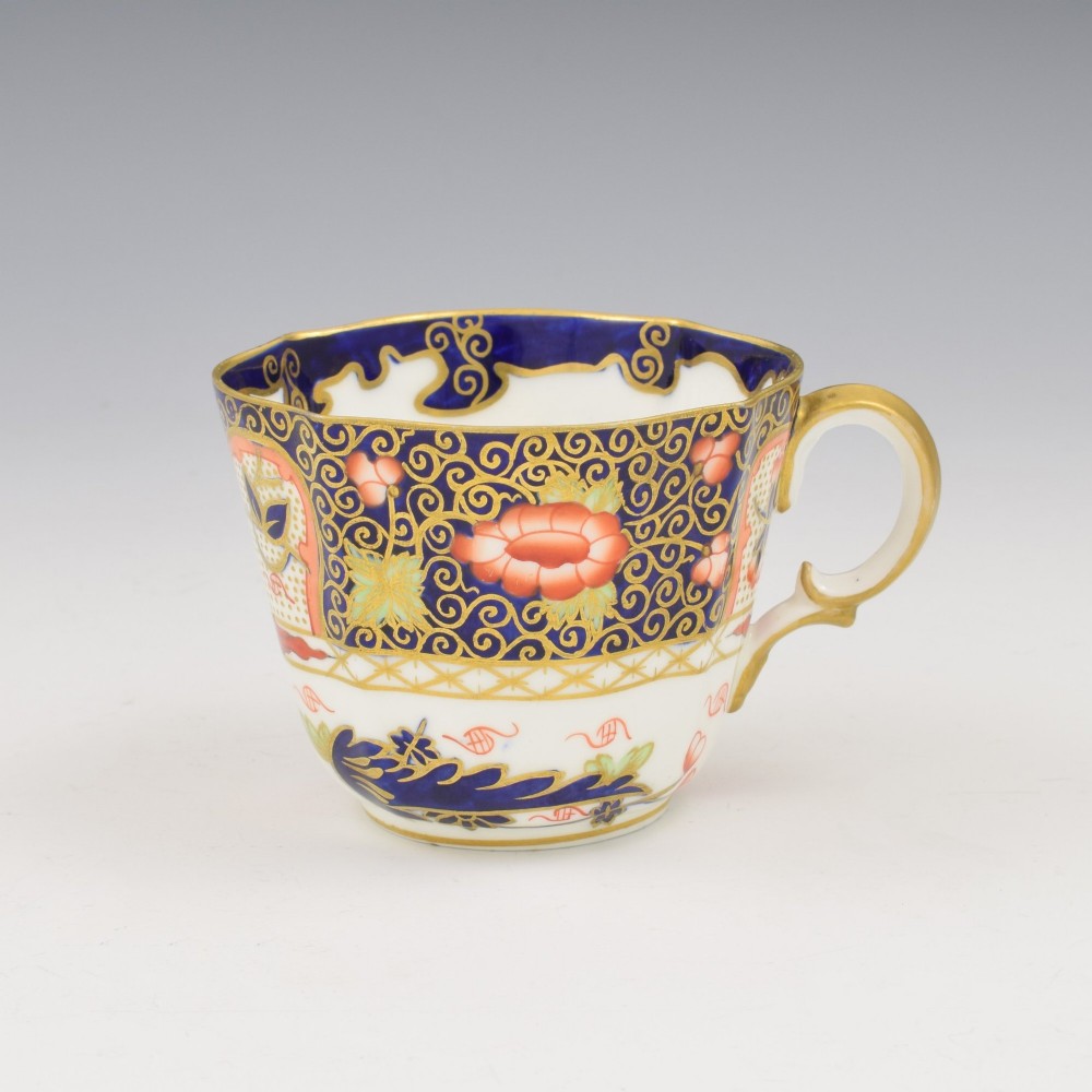 An Edwardian Royal Crown Derby porcelain coffee cup and matching saucer decorated in a rich cobalt blue, iron red, and gilt Imari pattern. View III