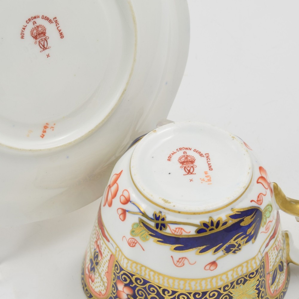 An Edwardian Royal Crown Derby porcelain coffee cup and matching saucer decorated in a rich cobalt blue, iron red, and gilt Imari pattern. View VIII