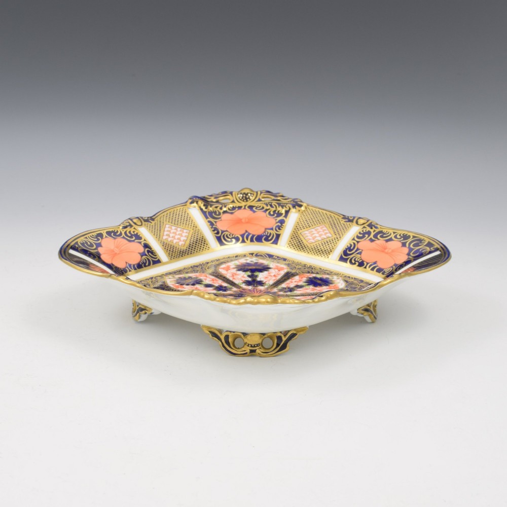 A shallow hexagonal bone china dish decorated in rich cobalt blue, iron red, and gold gilding, featuring pierced side handles and a footed base. View VIII