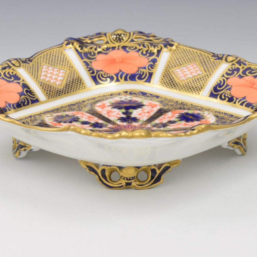 A shallow hexagonal bone china dish decorated in rich cobalt blue, iron red, and gold gilding, featuring pierced side handles and a footed base. View IX