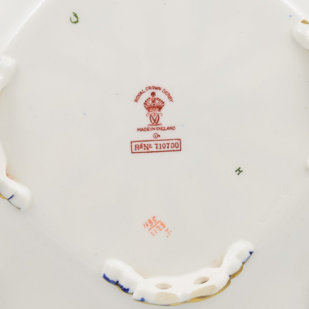 A shallow hexagonal bone china dish decorated in rich cobalt blue, iron red, and gold gilding, featuring pierced side handles and a footed base. View XII