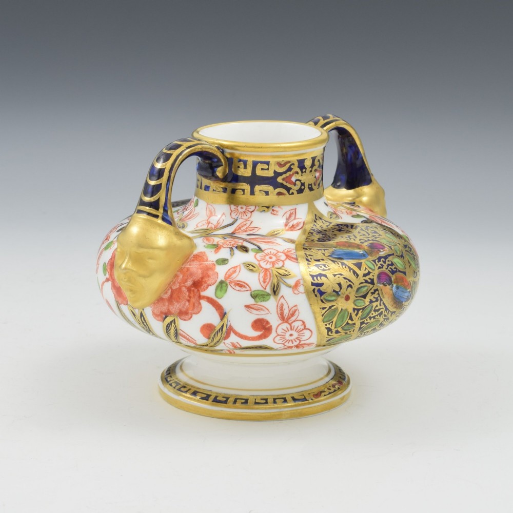 A Victorian Royal Crown Derby porcelain vase featuring twin gilded mask handles, intricate cobalt blue and gold panel decoration, and hand-painted floral motifs. View V