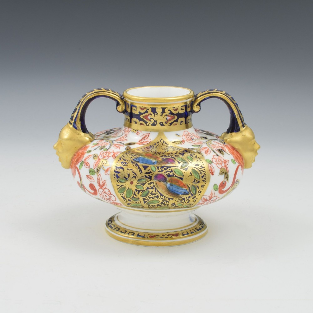 A Victorian Royal Crown Derby porcelain vase featuring twin gilded mask handles, intricate cobalt blue and gold panel decoration, and hand-painted floral motifs. View VI