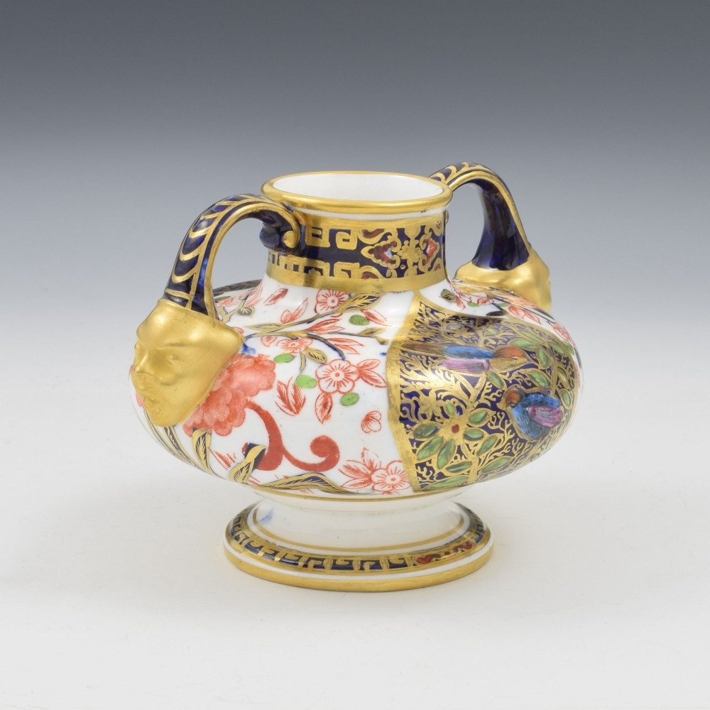 A Victorian Royal Crown Derby porcelain vase featuring twin gilded mask handles, intricate cobalt blue and gold panel decoration, and hand-painted floral motifs. View IX