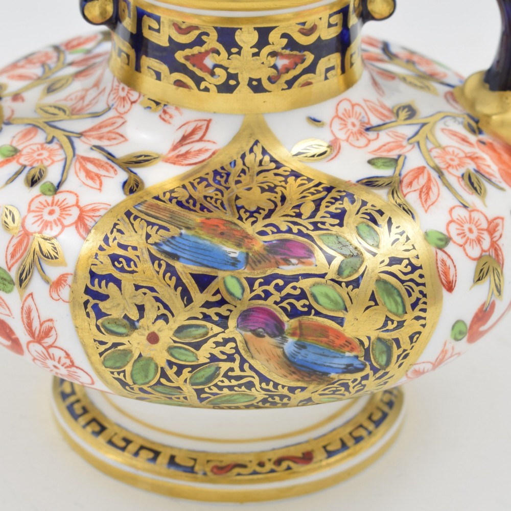 A Victorian Royal Crown Derby porcelain vase featuring twin gilded mask handles, intricate cobalt blue and gold panel decoration, and hand-painted floral motifs. View X