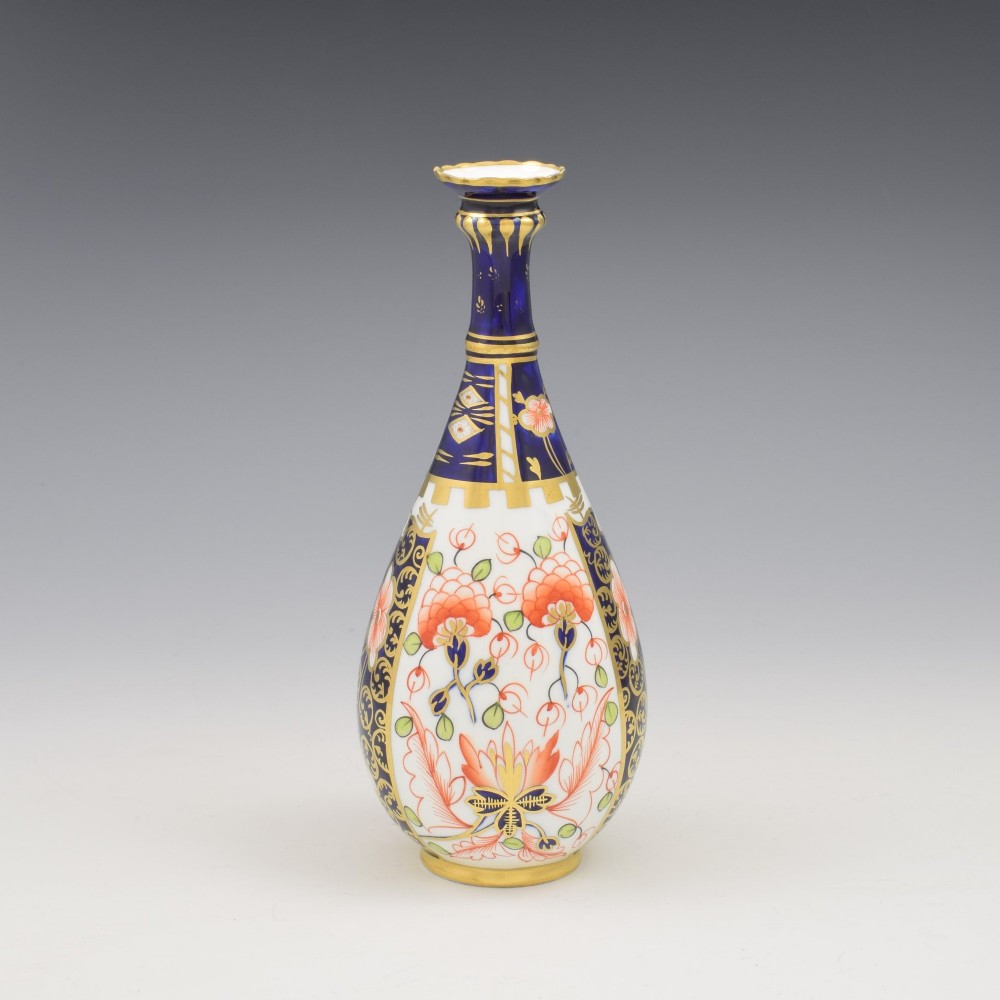 A slender porcelain stem vase featuring cobalt blue, iron red, and gilt hand-painted botanical motifs in the traditional Imari style. View IV