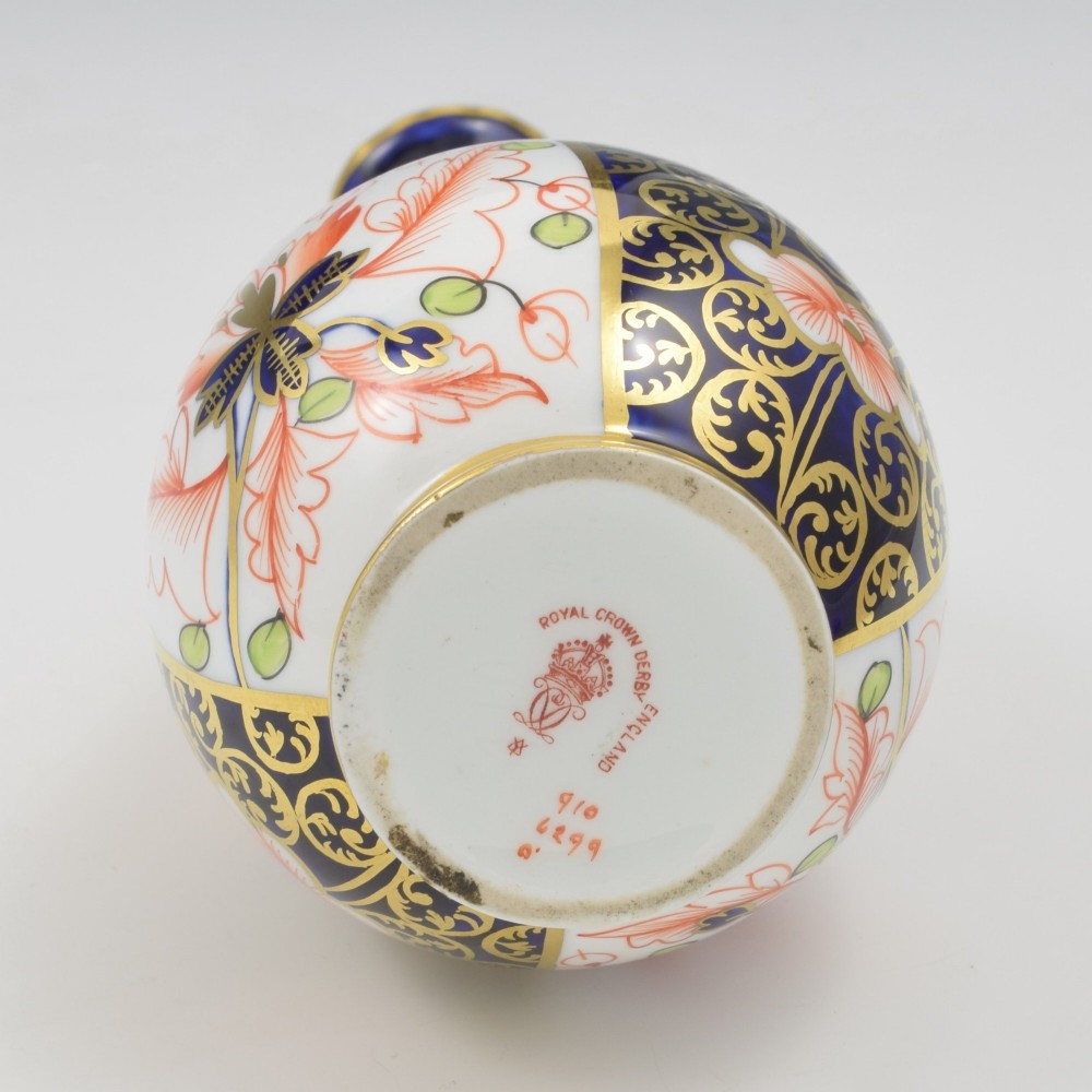 A slender porcelain stem vase featuring cobalt blue, iron red, and gilt hand-painted botanical motifs in the traditional Imari style. View V