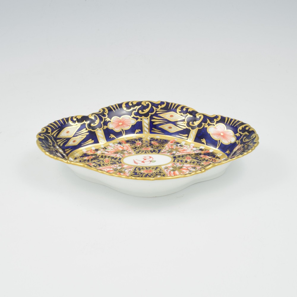 An oval antique Royal Crown Derby porcelain serving dish featuring intricate cobalt blue, coral red, and heavy gold leaf Imari pattern 6299 details with a lobed edge. View III