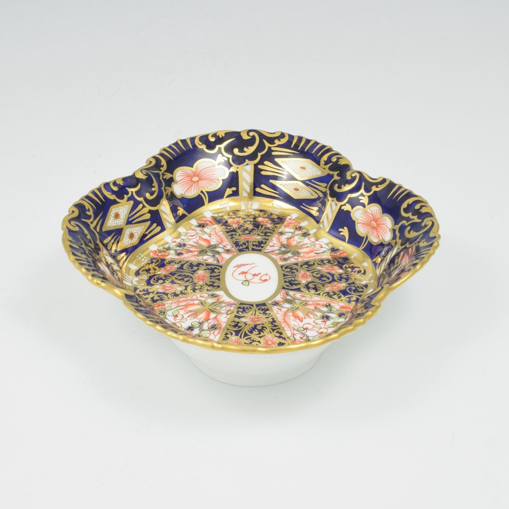 An oval antique Royal Crown Derby porcelain serving dish featuring intricate cobalt blue, coral red, and heavy gold leaf Imari pattern 6299 details with a lobed edge. View VI
