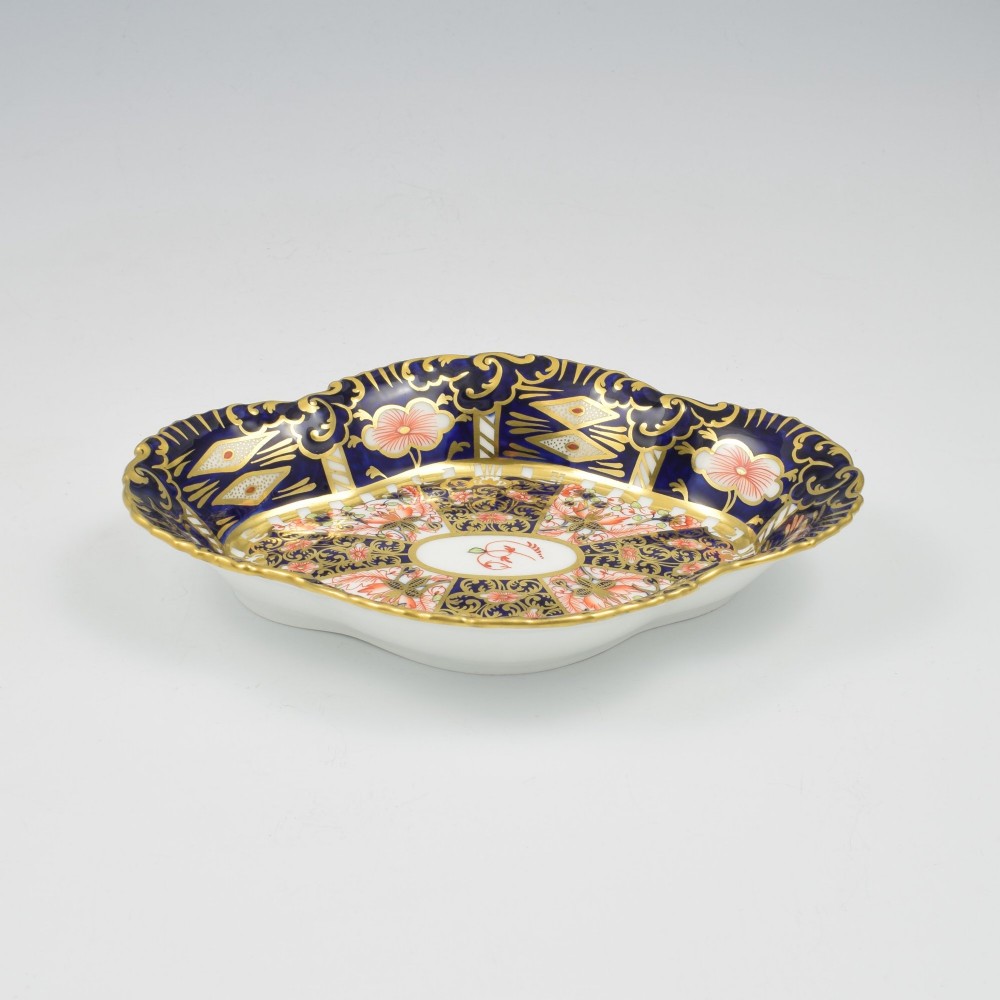 An oval antique Royal Crown Derby porcelain serving dish featuring intricate cobalt blue, coral red, and heavy gold leaf Imari pattern 6299 details with a lobed edge. View VII