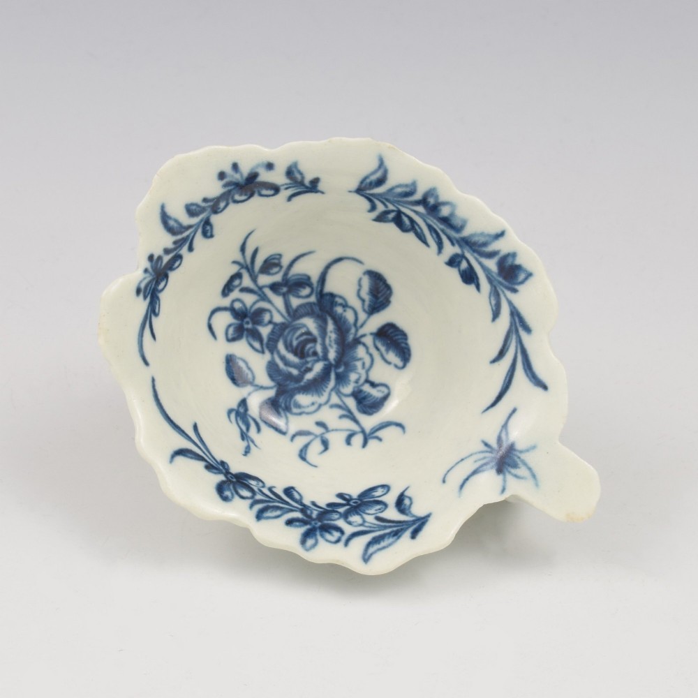 A leaf-shaped soft-paste porcelain butter boat decorated with an underglaze blue hand-painted rose motif and a floral running border. View II