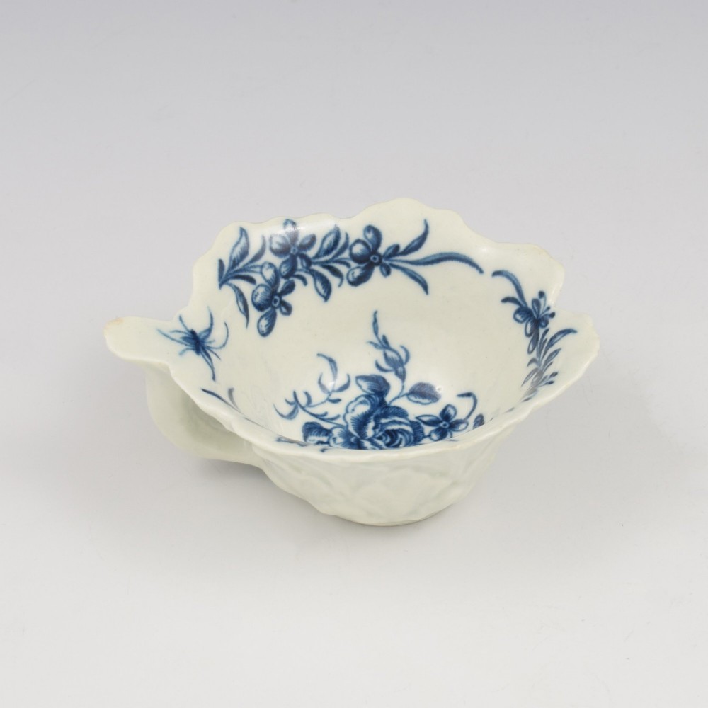 A leaf-shaped soft-paste porcelain butter boat decorated with an underglaze blue hand-painted rose motif and a floral running border. View VI