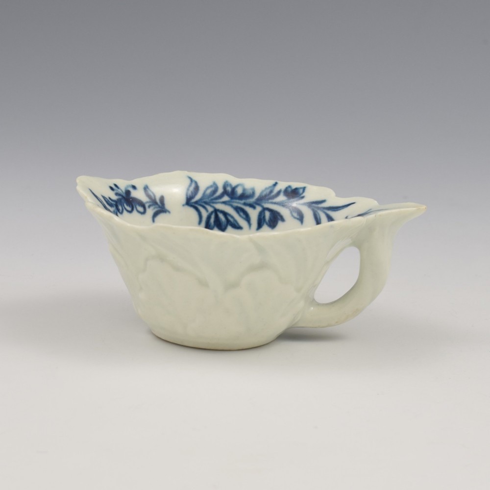 A leaf-shaped soft-paste porcelain butter boat decorated with an underglaze blue hand-painted rose motif and a floral running border. View VIII