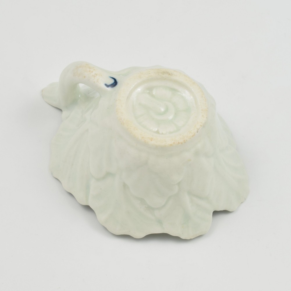 A leaf-shaped soft-paste porcelain butter boat decorated with an underglaze blue hand-painted rose motif and a floral running border. View X