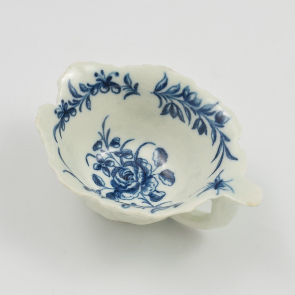 A leaf-shaped soft-paste porcelain butter boat decorated with an underglaze blue hand-painted rose motif and a floral running border. View XIV