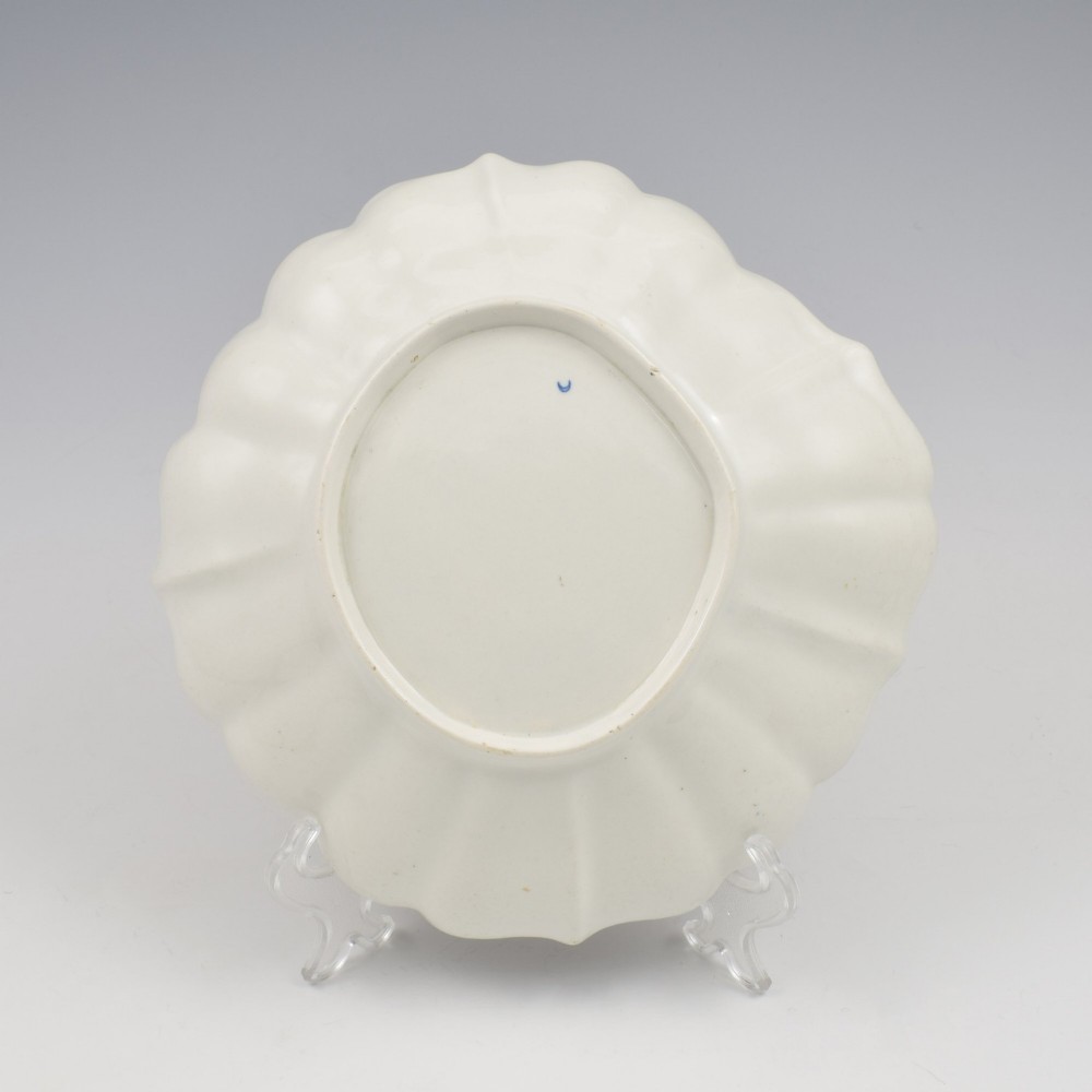 An 18th-century circular soft-paste porcelain dish with a scalloped rim, decorated in the Rich Queens pattern featuring cobalt blue gilt panels alternating with painted red and green floral motifs. View VII
