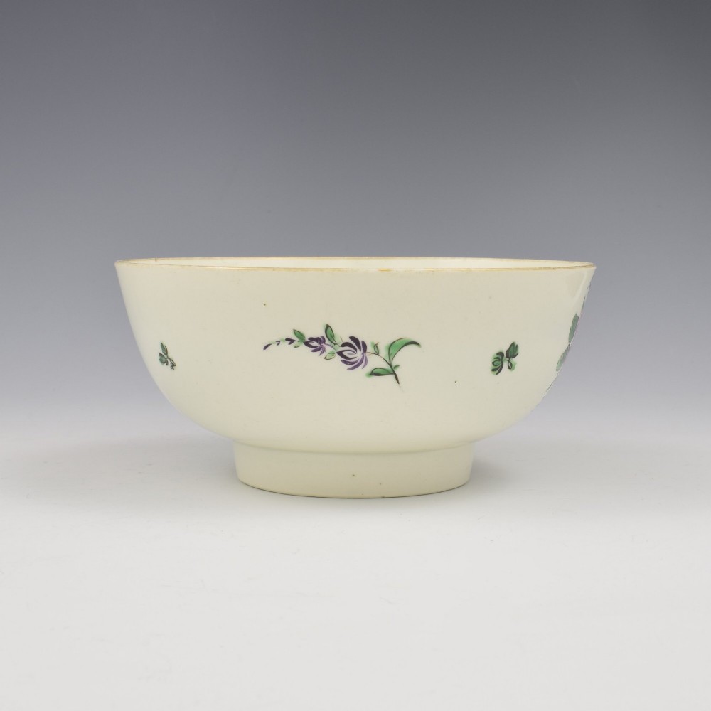 An 18th-century cream soft-paste porcelain slop bowl decorated with hand-painted floral motifs on a short foot rim. View II