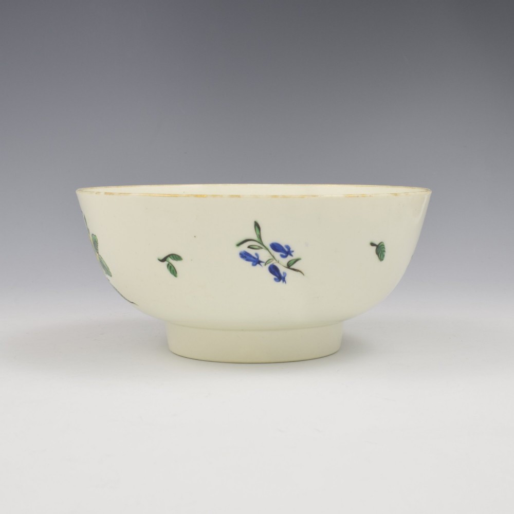 An 18th-century cream soft-paste porcelain slop bowl decorated with hand-painted floral motifs on a short foot rim. View IV