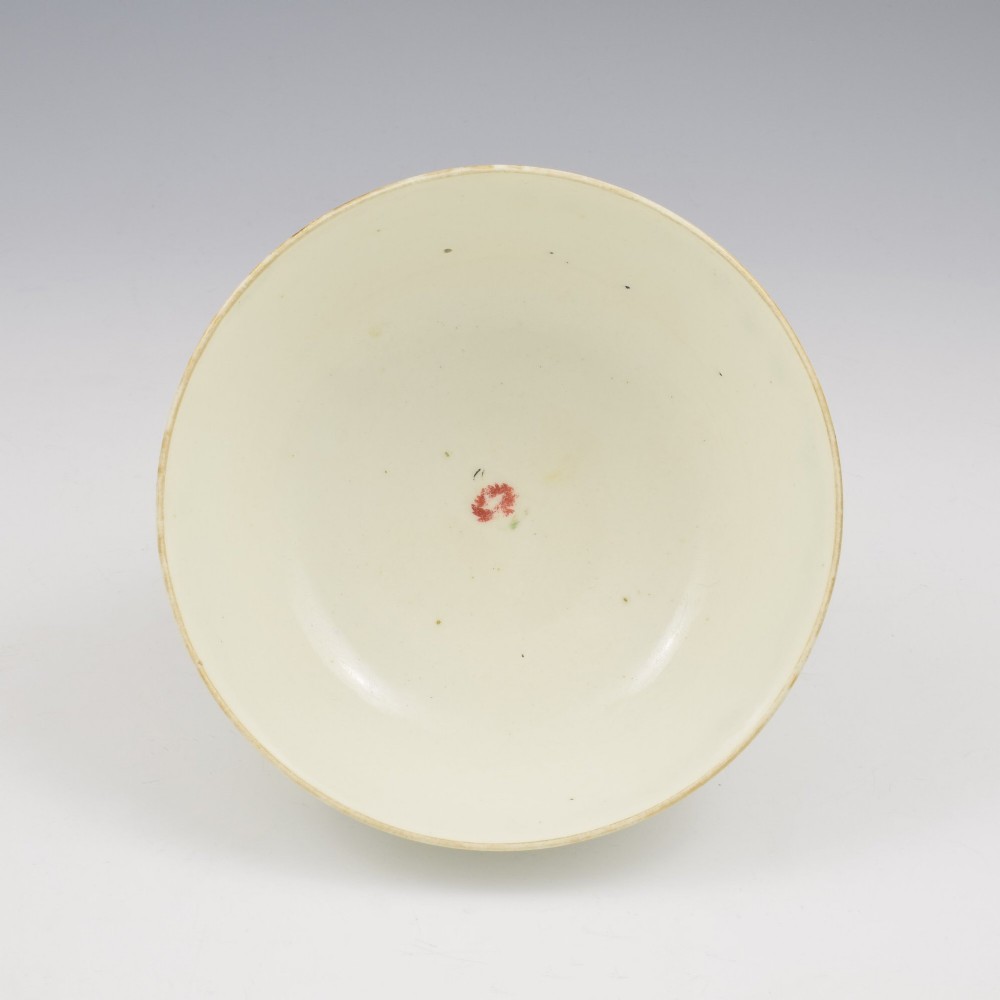 An 18th-century cream soft-paste porcelain slop bowl decorated with hand-painted floral motifs on a short foot rim. View V