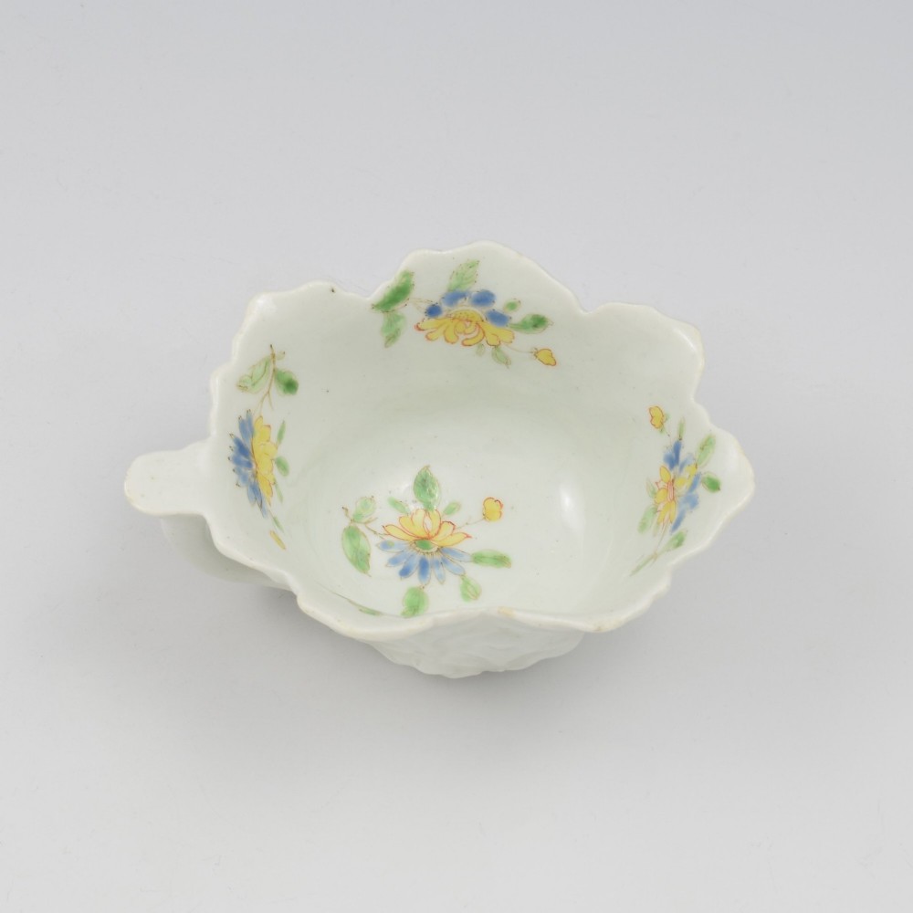 An eighteenth-century Dr Wall First Period Worcester soft-paste porcelain butter boat featuring hand-painted polychrome floral enamel sprigs and a leaf-moulded rim. View II